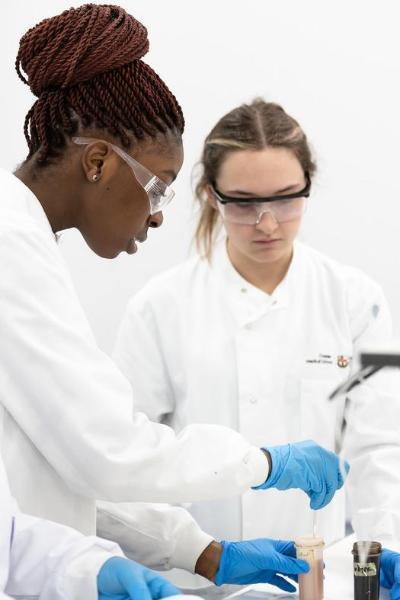 A group of female students on the BSc Biomedical Science degree, learning essential laboratory skills training and research.