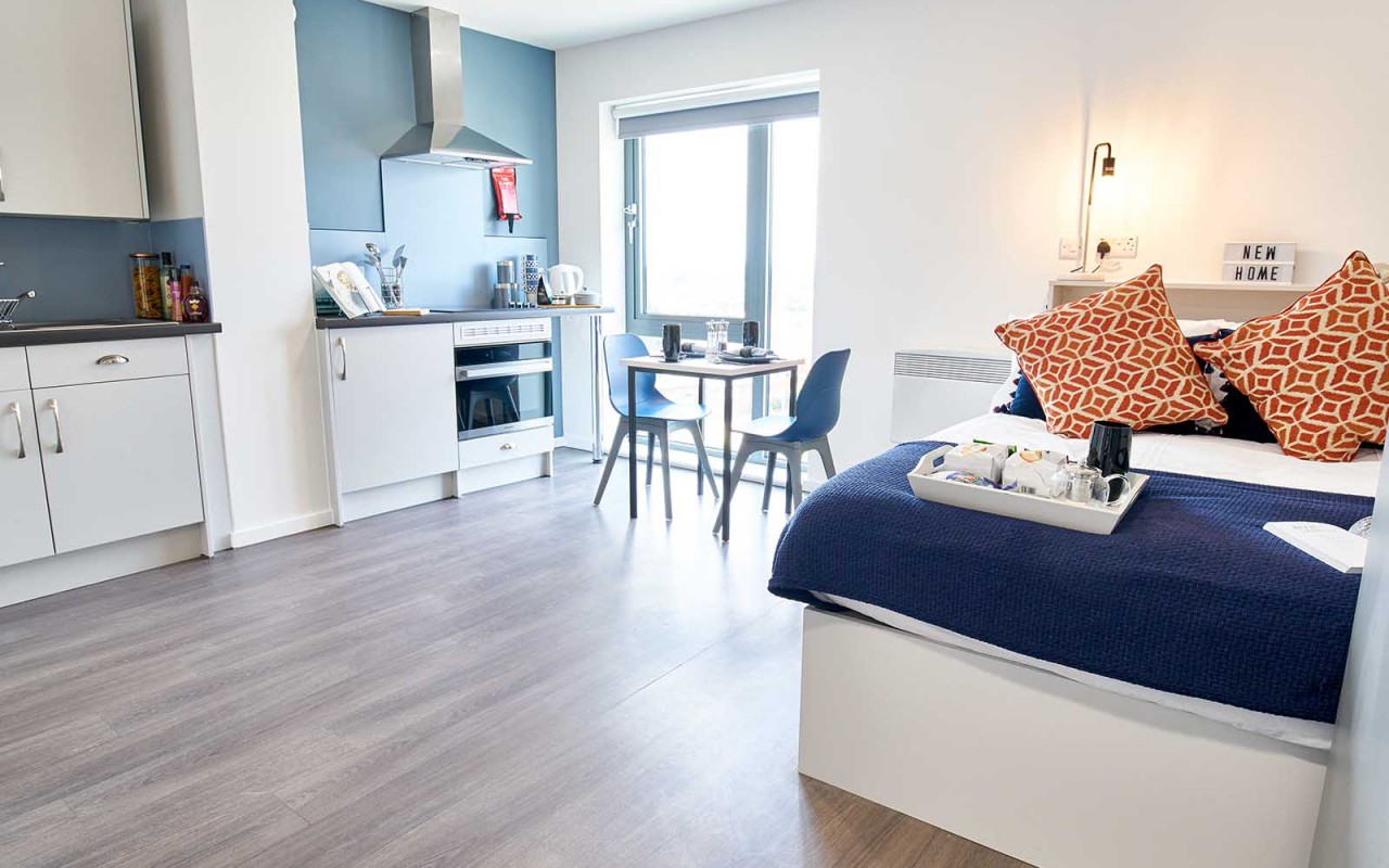 A bed and table in Granary Studios' room