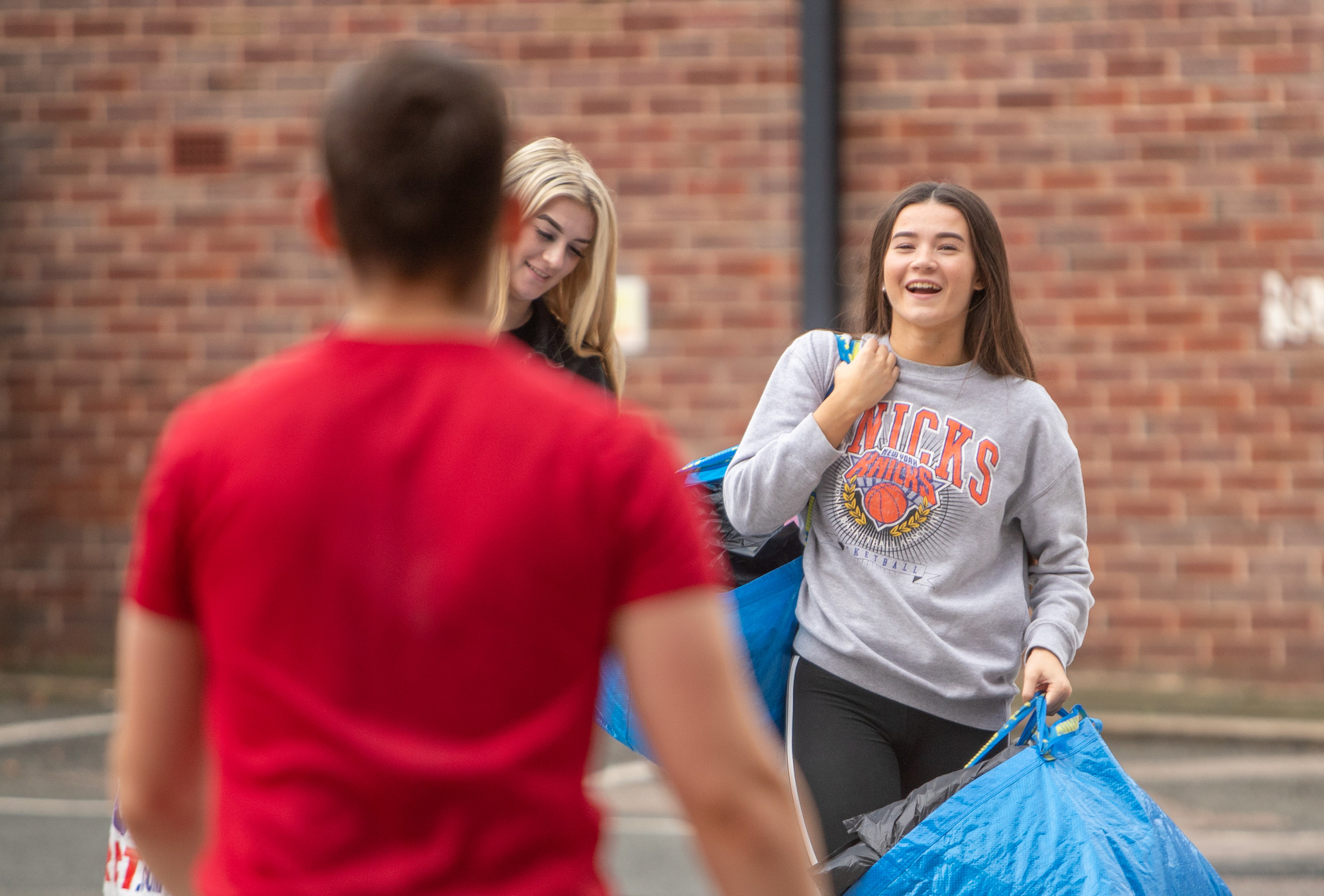 A student arriving on campus with bags