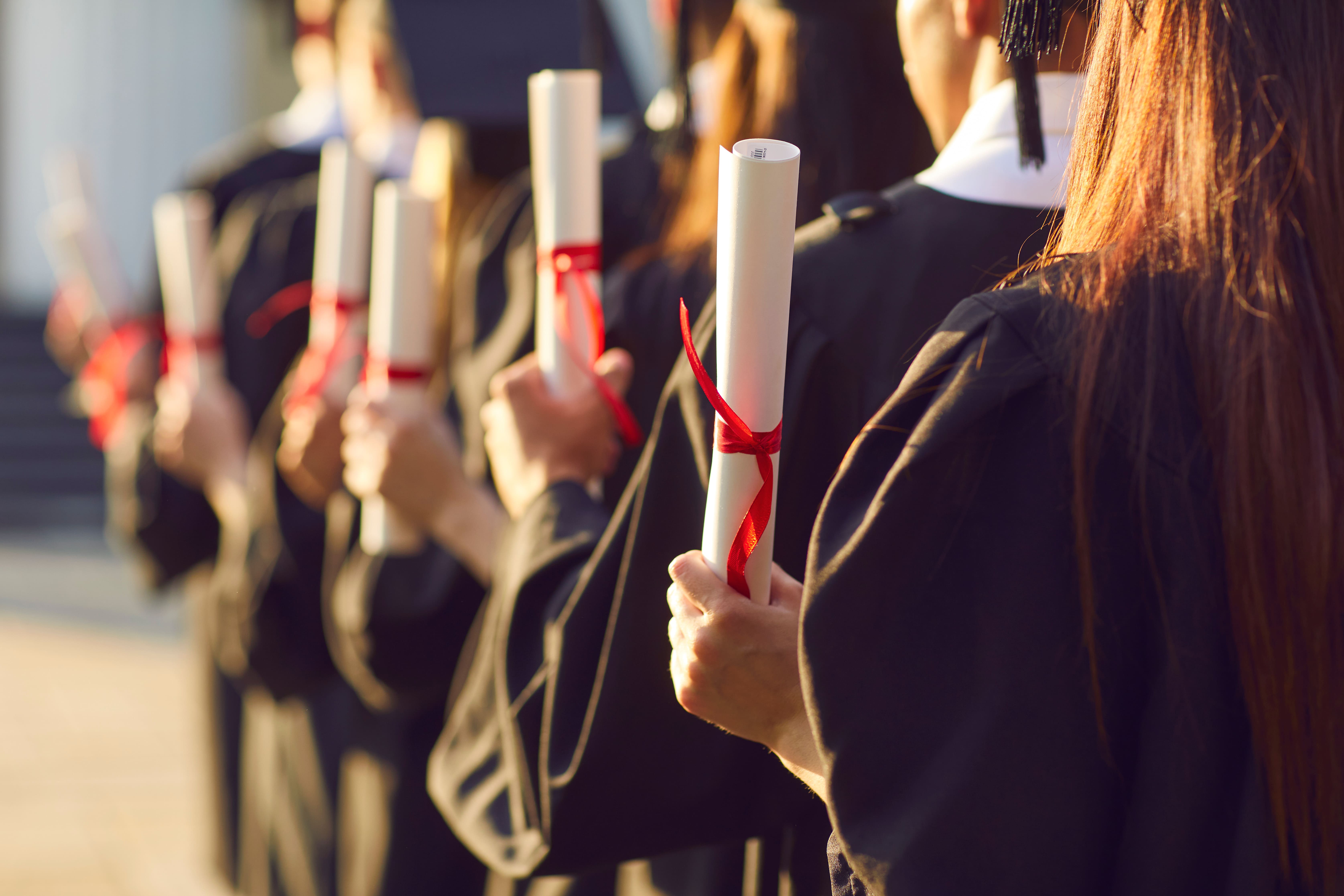 graduates holding certificate scrolls