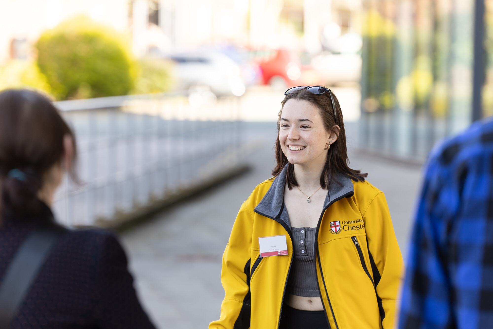 A student ambassador smiling in front of visitors about to start a campus tour