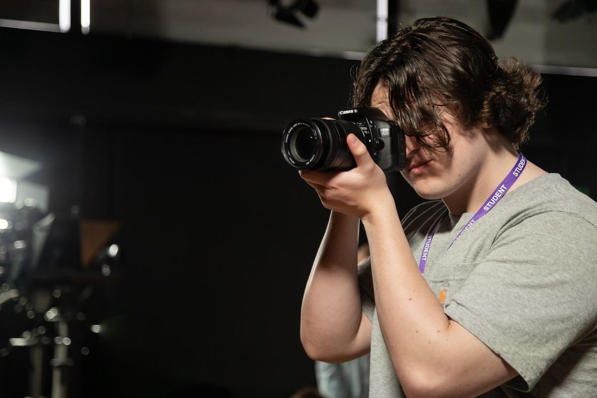 Photography BA (Hons) student using a professional DSLR camera in a university studio, developing practical photography and creative visual skills.