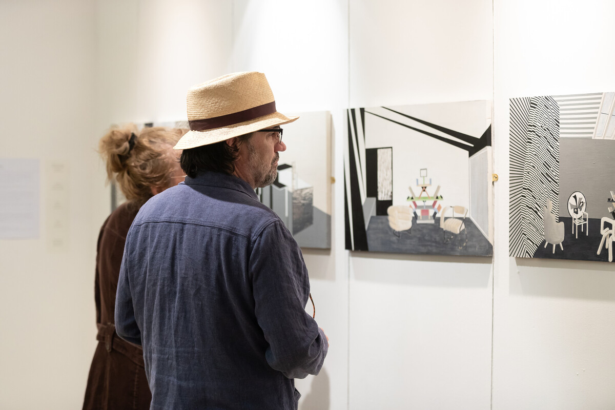 A man looking at photography printed artwork in gallery space