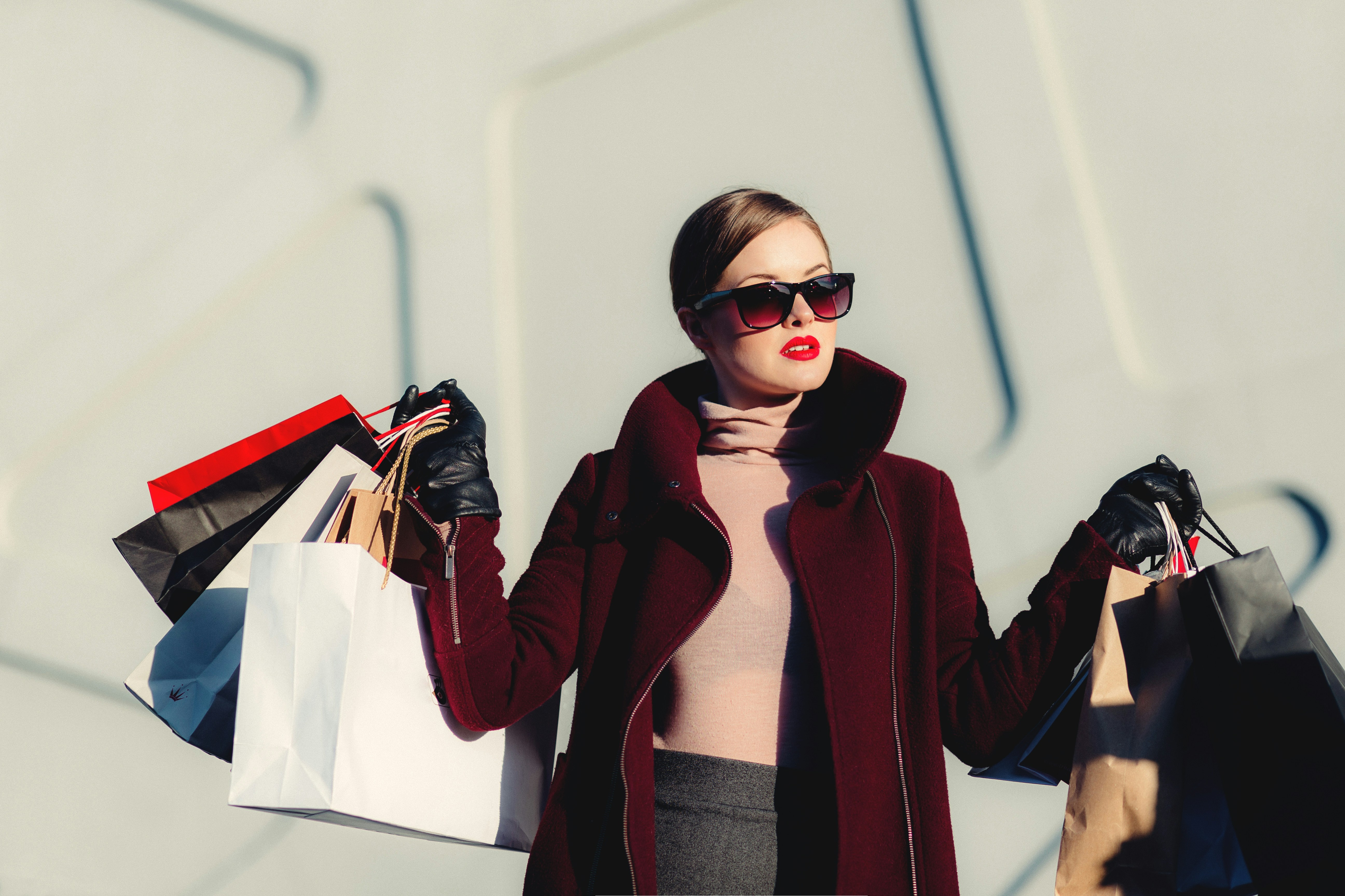 a lady in sunglasses with shopping bags