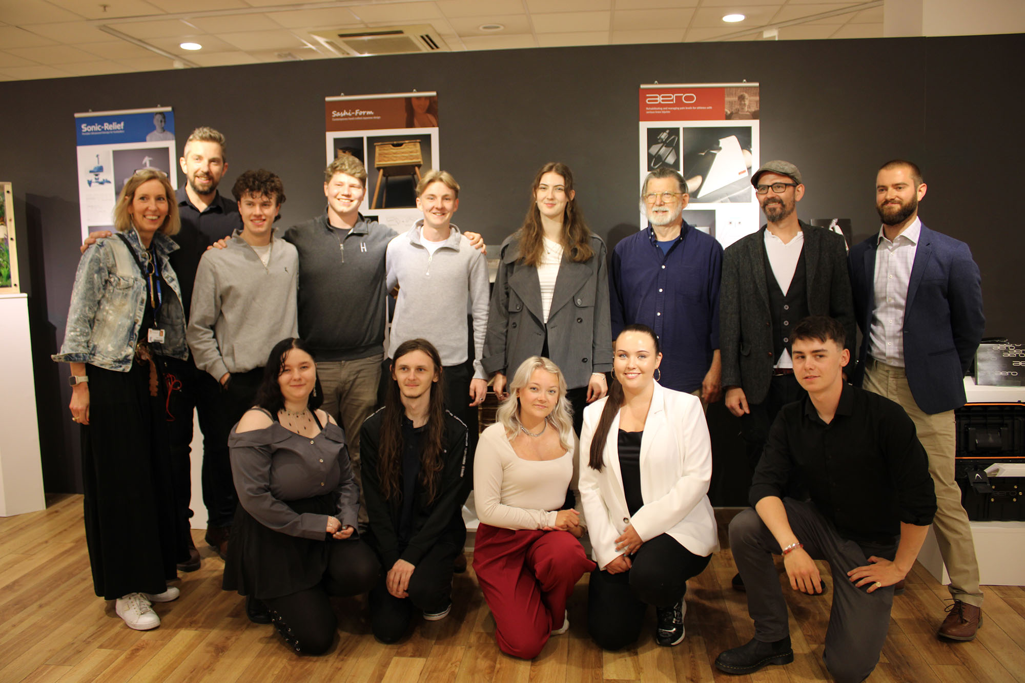 Product design students and lecturers smiling in group photo