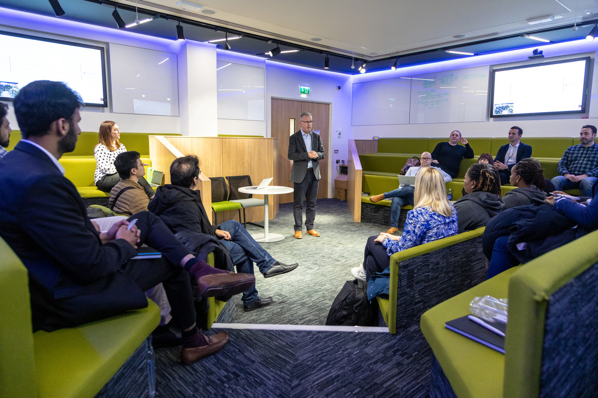 A group of people in a room having a business meeting