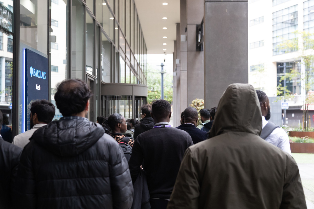 A group of people walking in a corridor, heading towards meeting room.