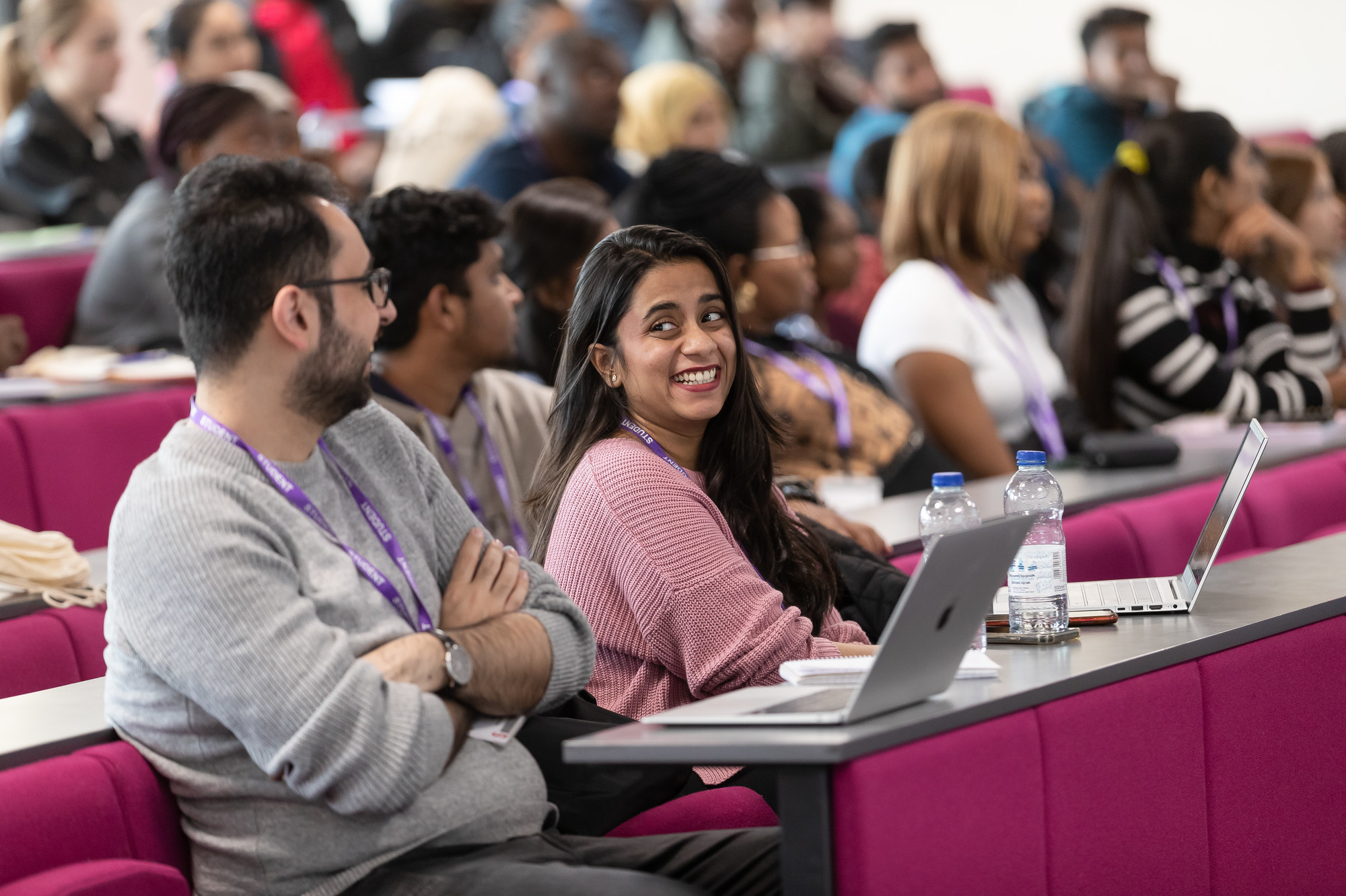 Student smiling at another student during a lecture