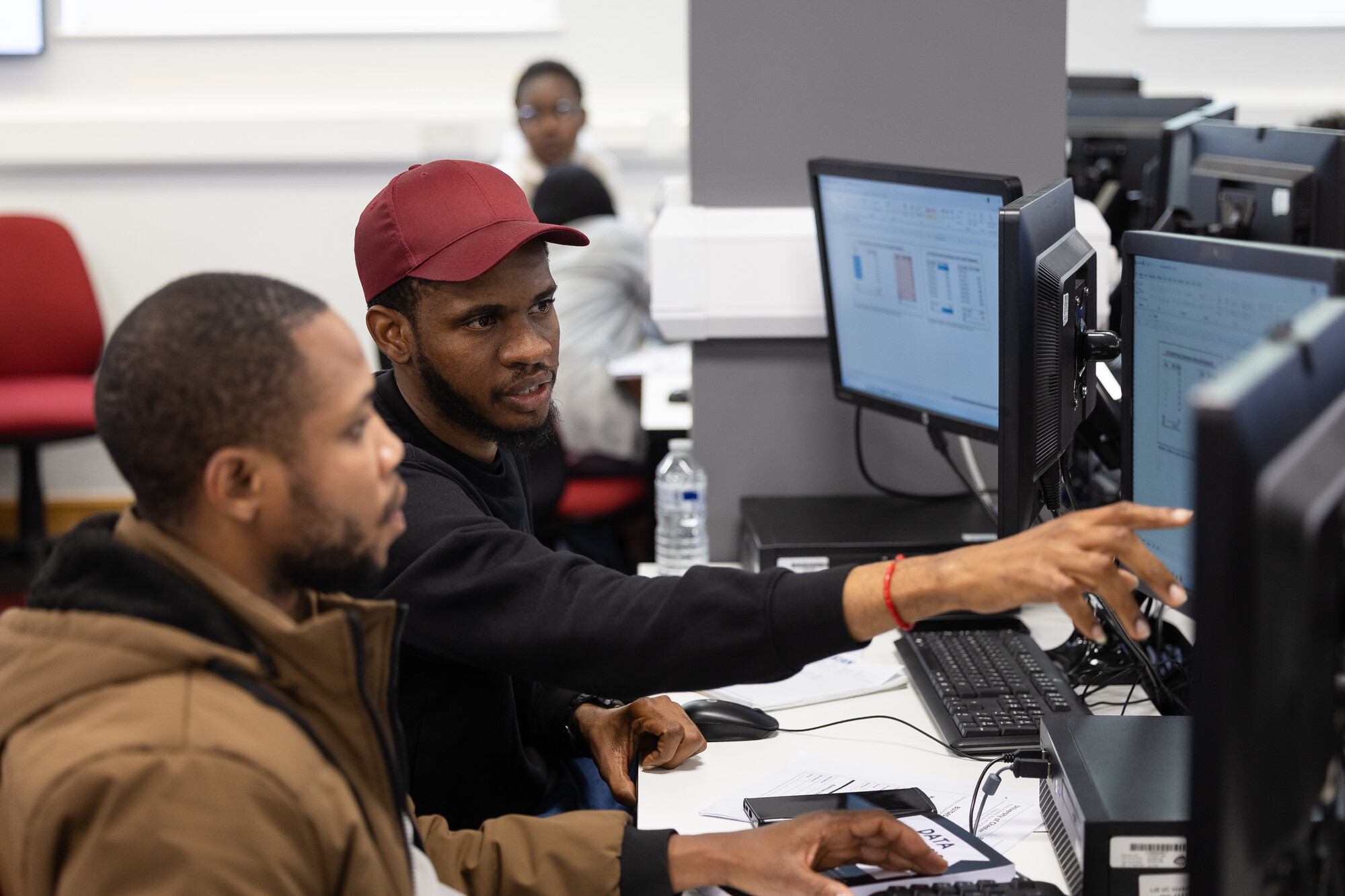 Two students sitting at computer screens in the Fintech Suite
