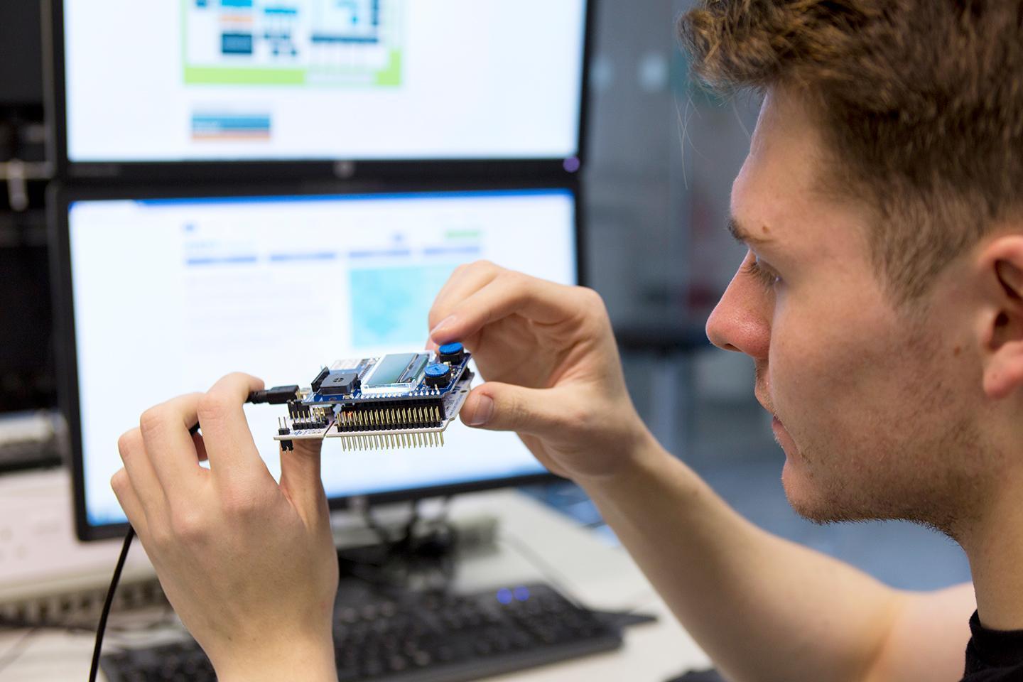 Undergraduate student assembling electronic hardware while studying Computer Science and Electronic Engineering BSc (Hons).