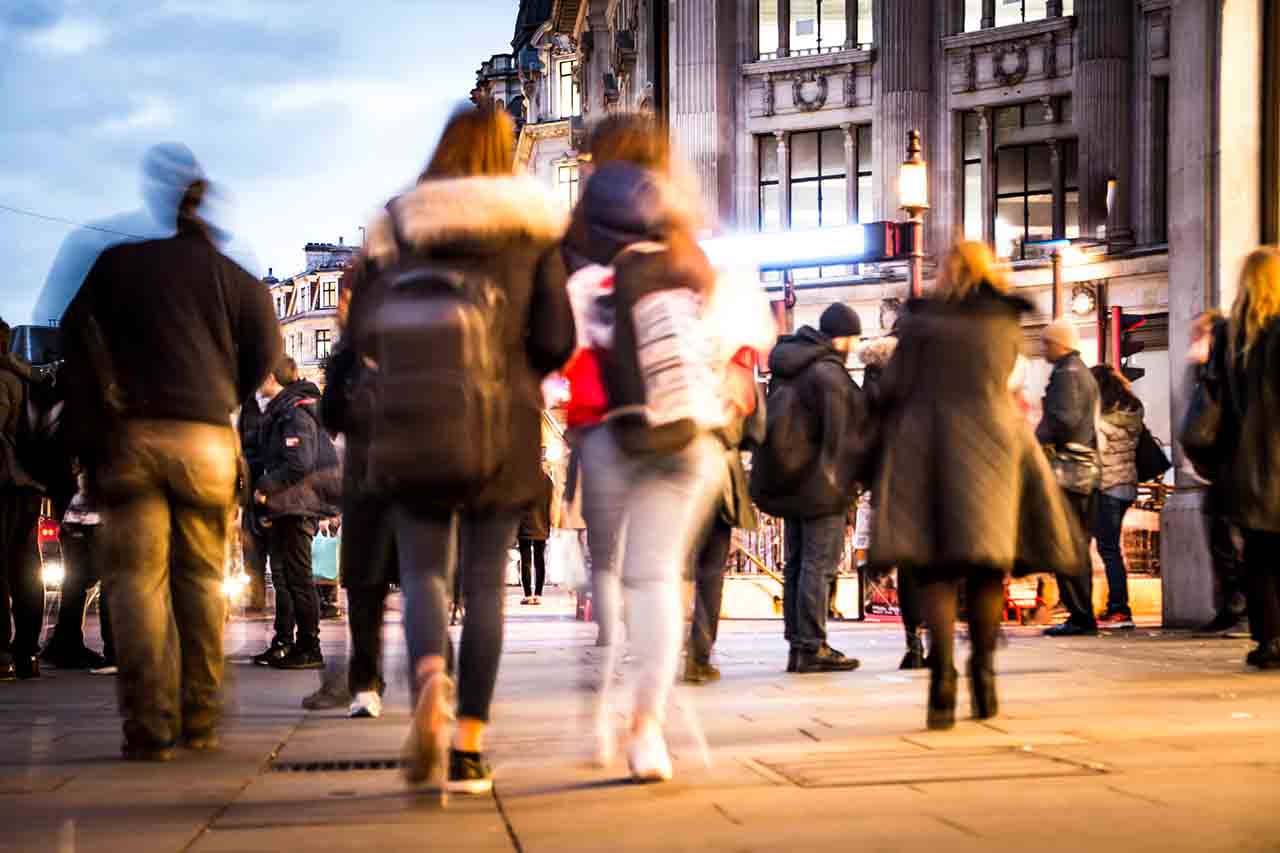 A group walking in the street of a town centre shopping area.