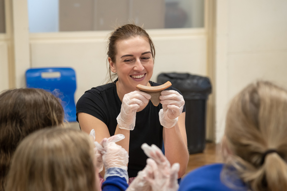 A woman holds bread, emphasising the importance of nourishment and support in a part-time PGCE Primary QTS course.