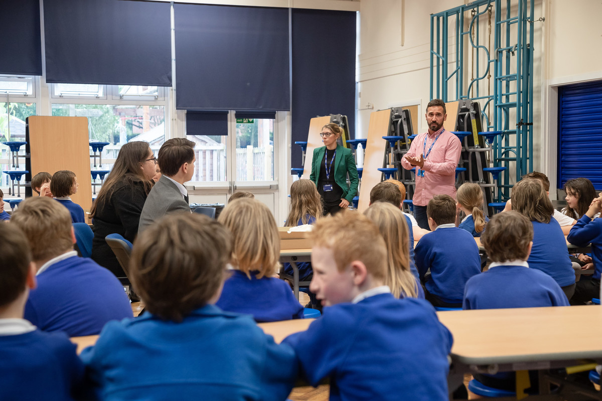 male and female teachers standing in front of a large group of children