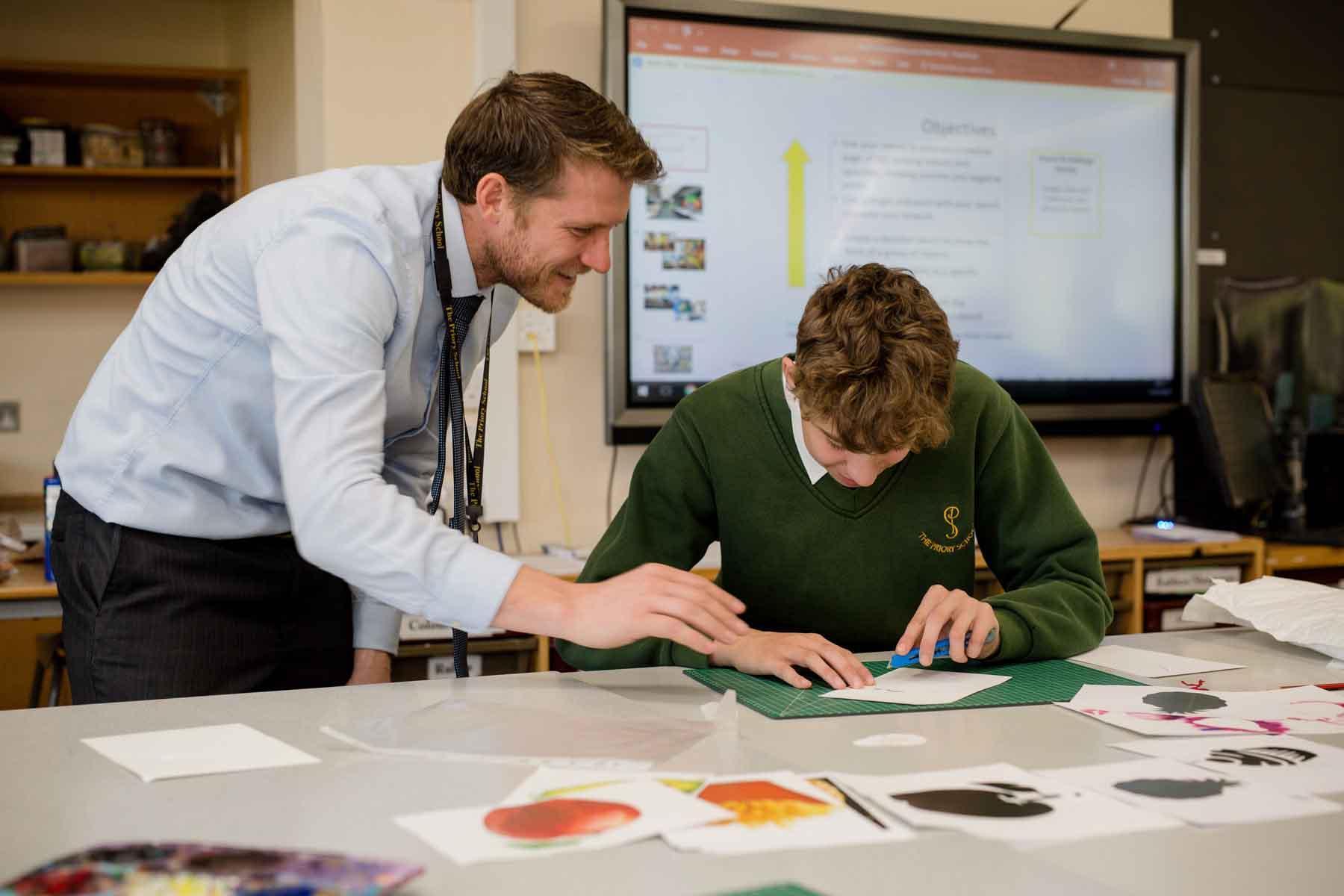 Education professional supports a learner during a classroom activity, demonstrating leadership, management and educational support skills relevant to the School Business Leadership (Top-Up) BA (Hons) at the University of Chester.