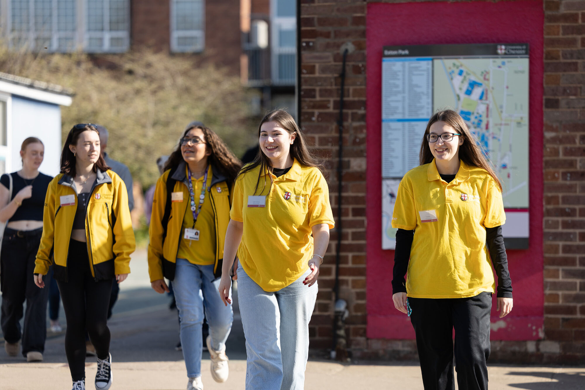 Friendly student ambassadors leading prospective applicants across campus during an open and applicant day experience.