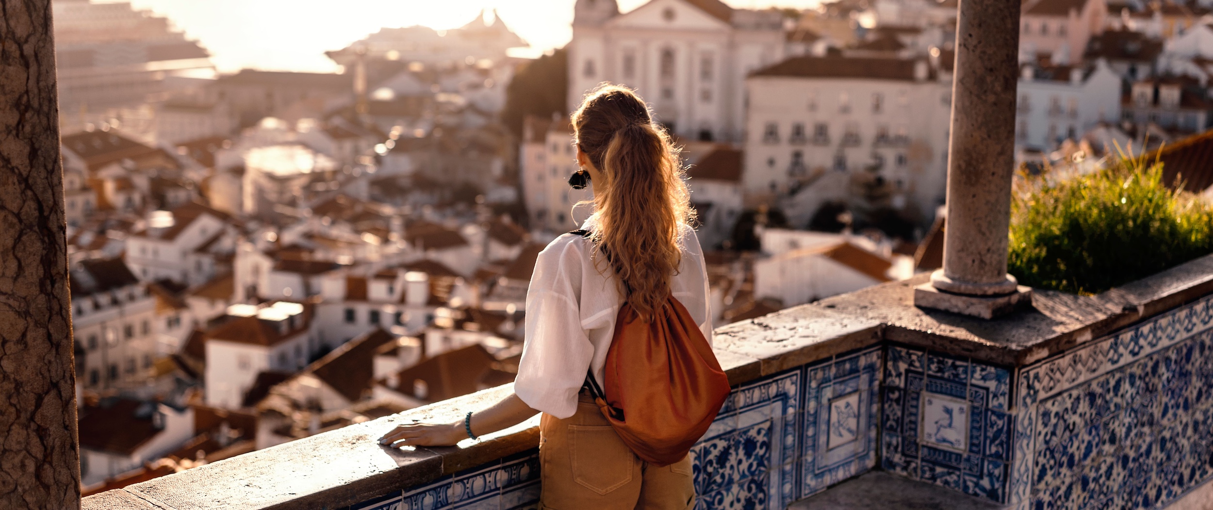 Female tourist looking at old town from balcony