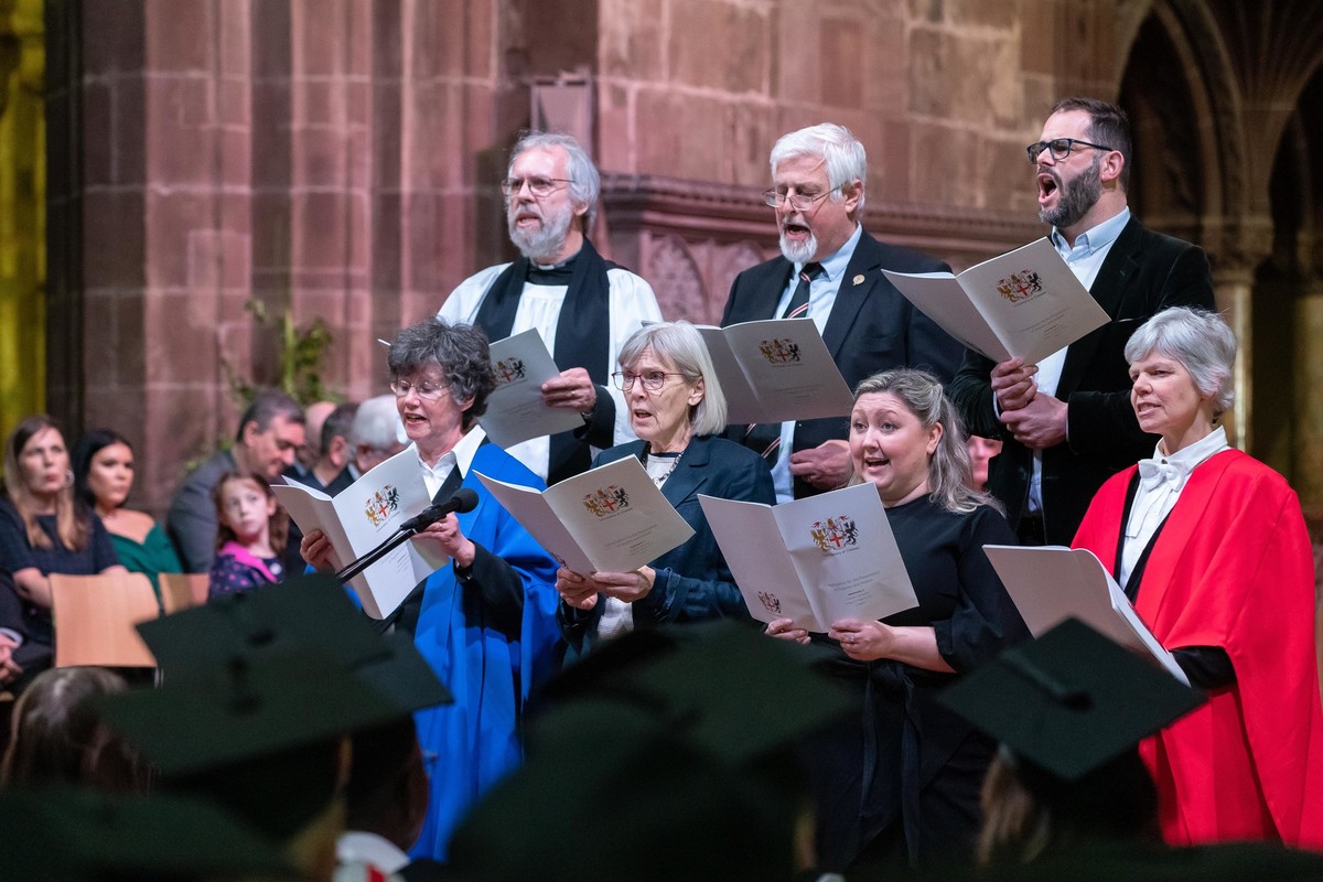 A group of people singing at a graduation ceremony