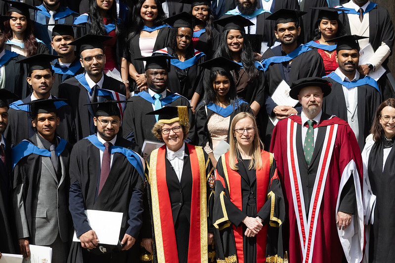 A group of students and staff wearing graduation clothing