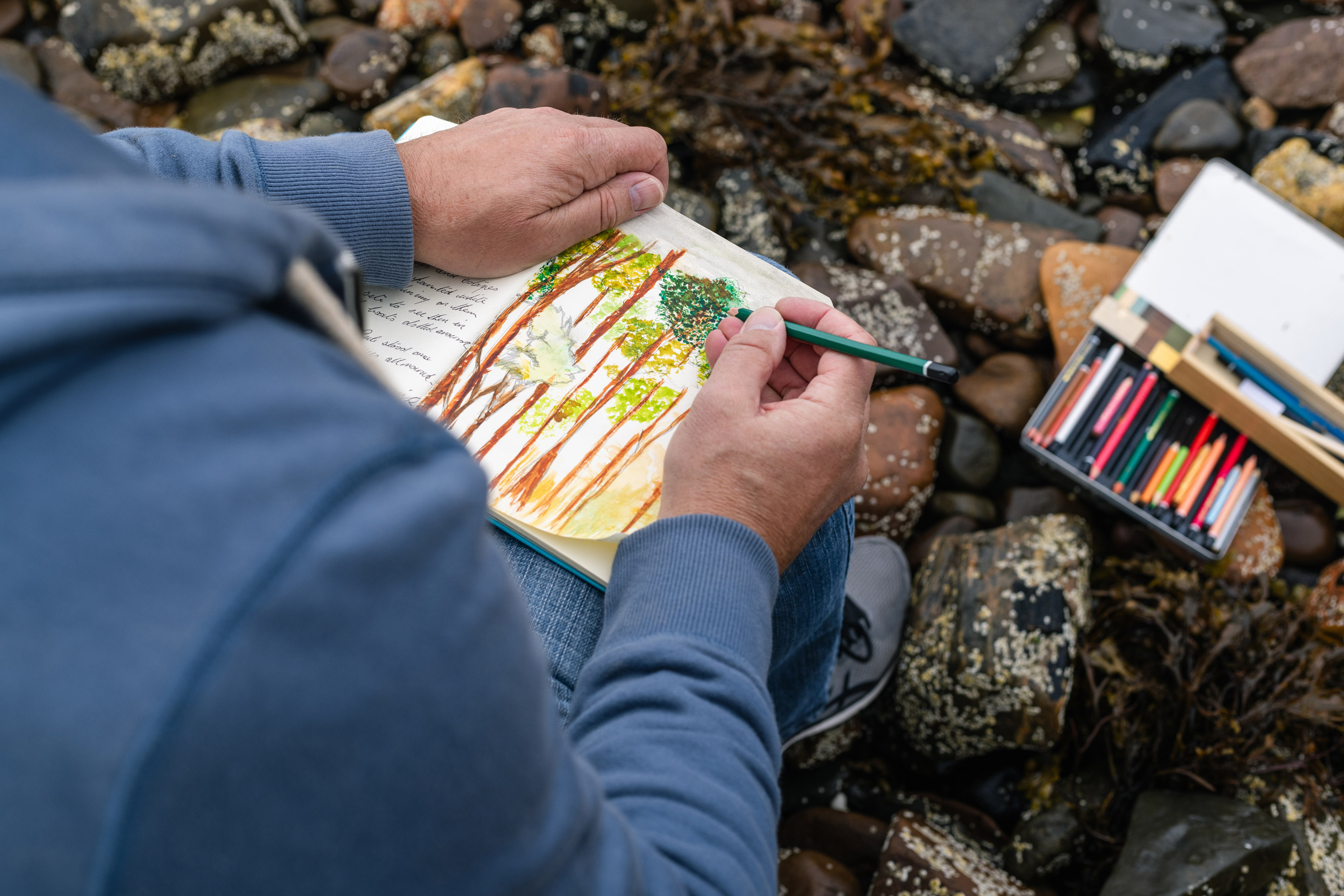 A person drawing in a sketchbook