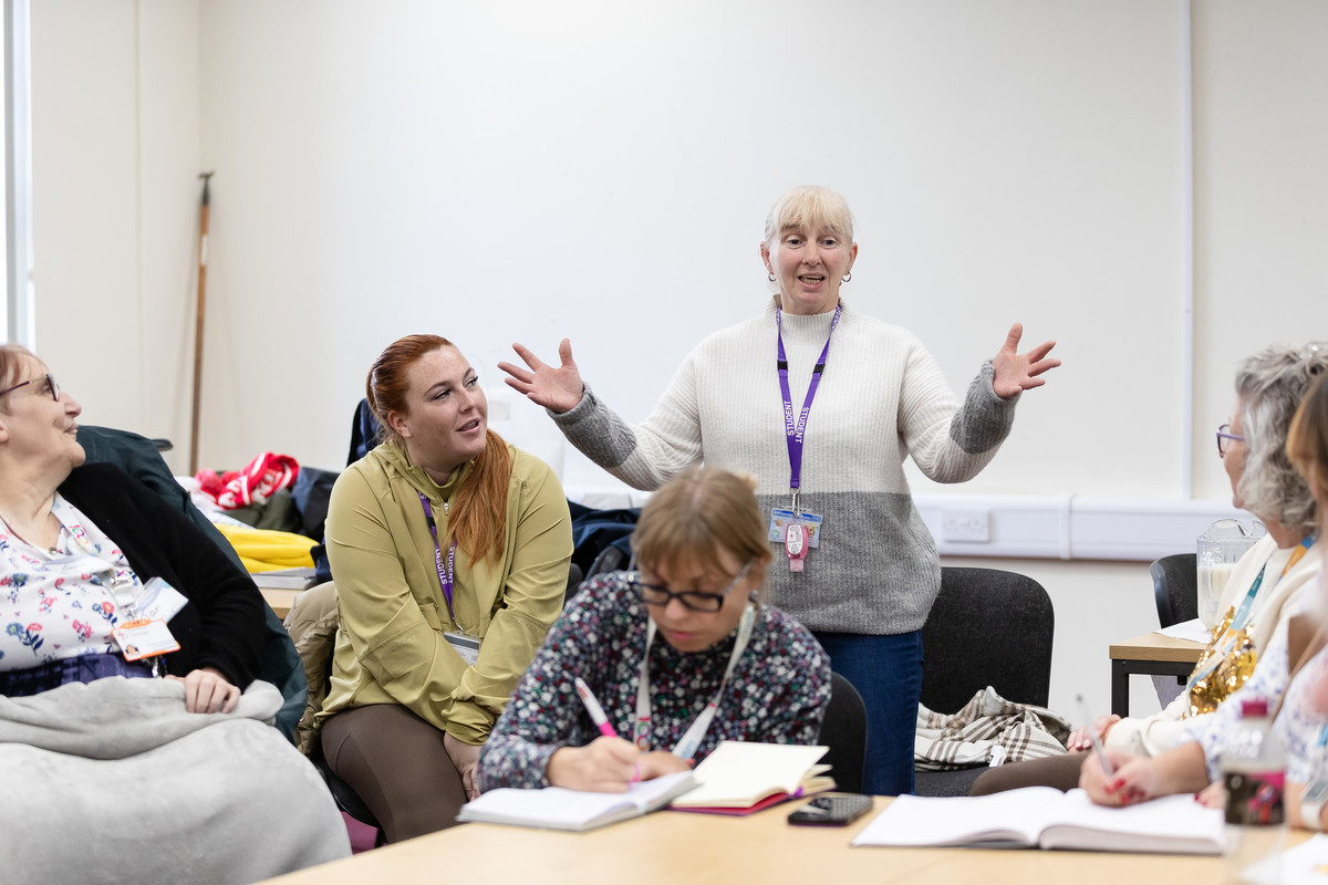 A group of people together in a meeting