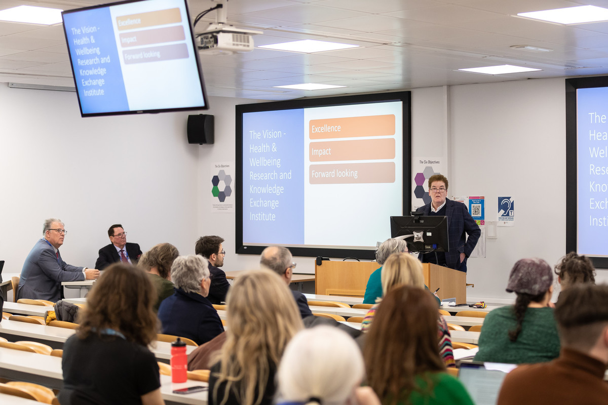 A person giving a presentation in front of a group of seated people