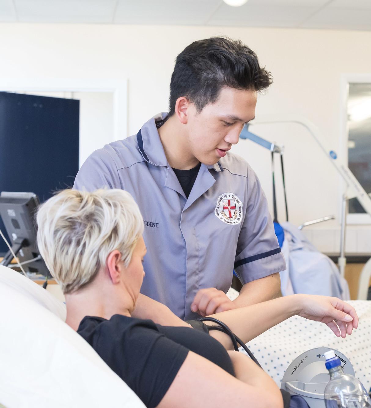 Nursing students providing patient care in a clinical simulation environment at the University of Chester, reflecting the Specialist Practice Community (District Nursing) PGDip and its focus on community healthcare, clinical assessment and patient-centred practice.