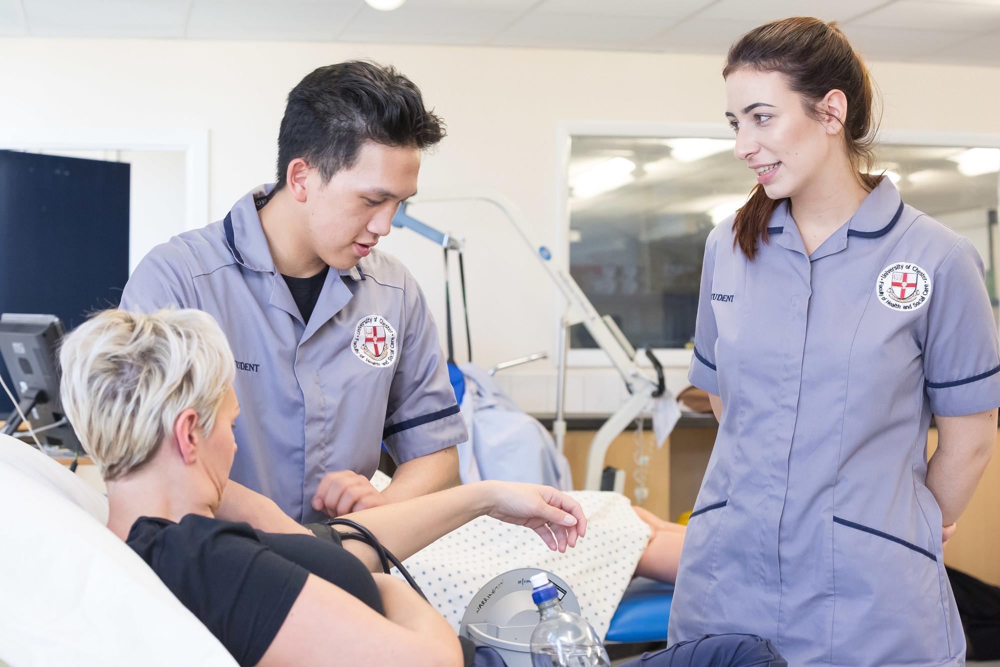 Nursing students providing patient care in a clinical simulation environment at the University of Chester, reflecting the Specialist Practice Community (District Nursing) PGDip and its focus on community healthcare, clinical assessment and patient-centred practice.