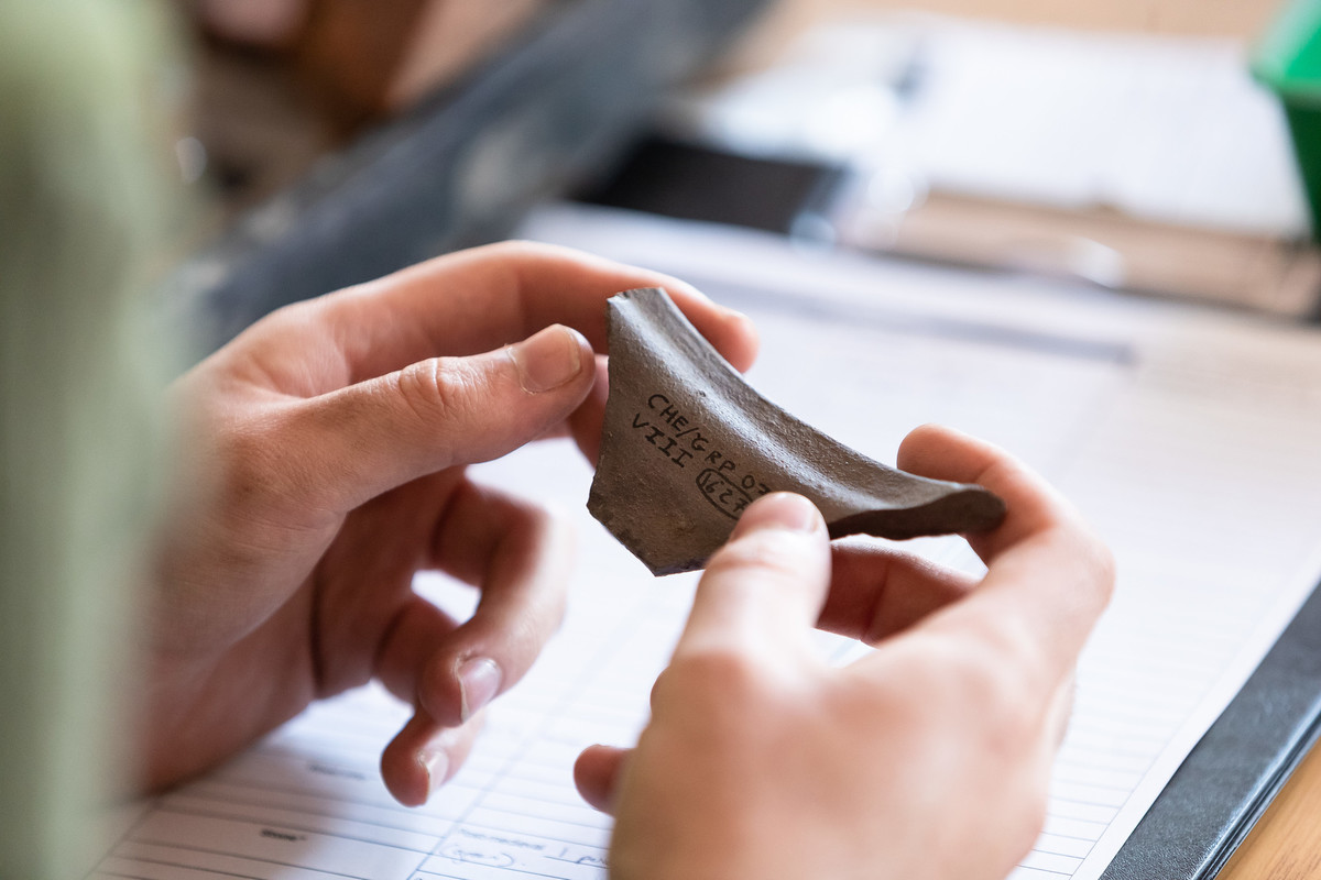 person holding roman artefact