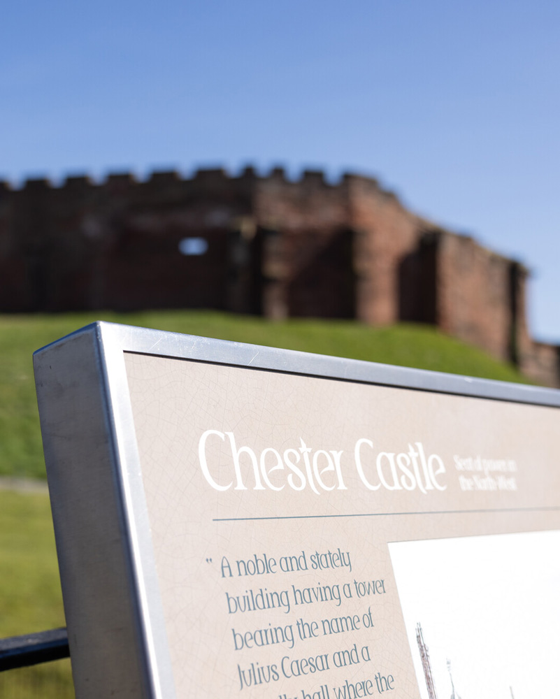 Exterior photograph of Chester Castle with an information board in focus.