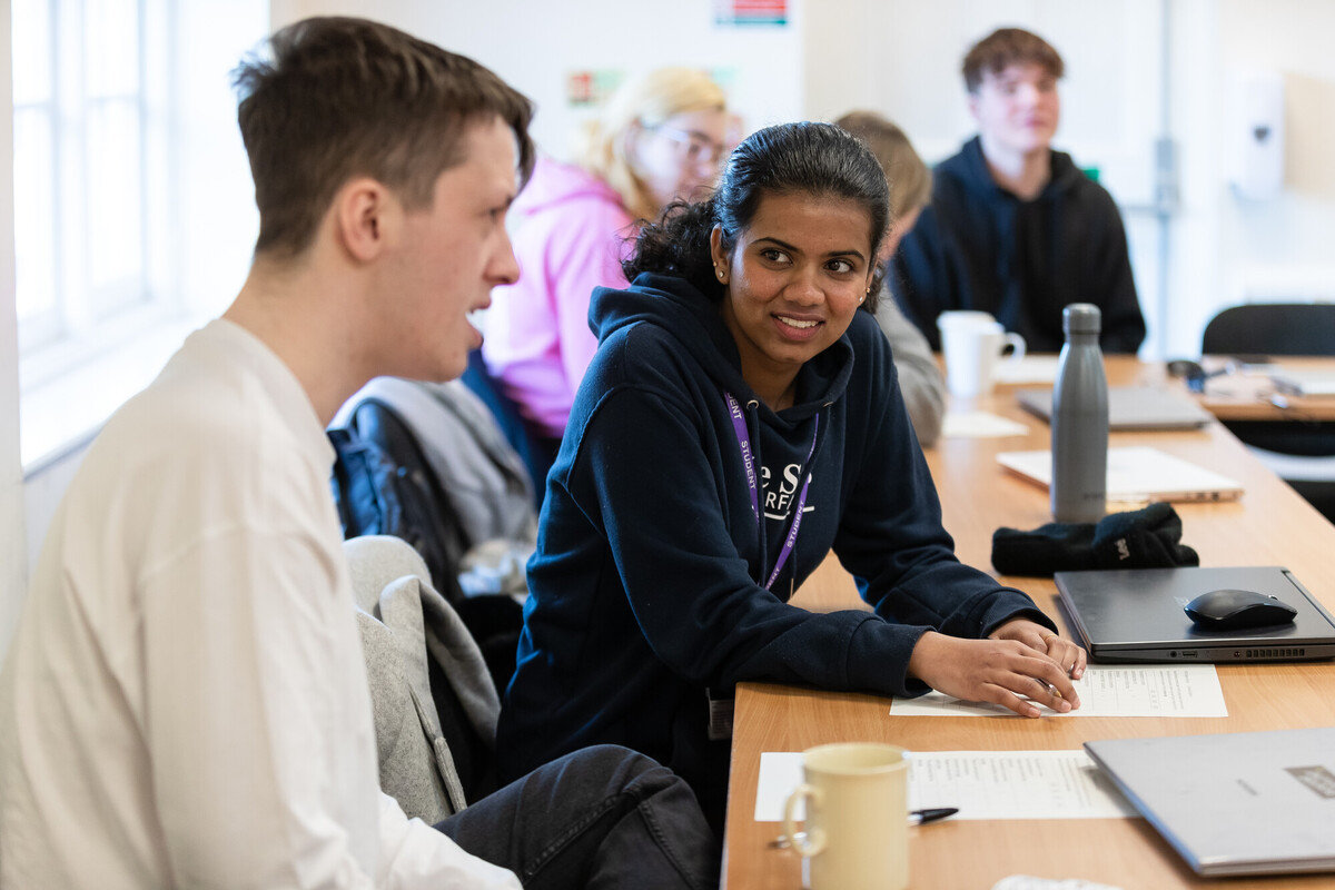 students smiling at desks in classroom