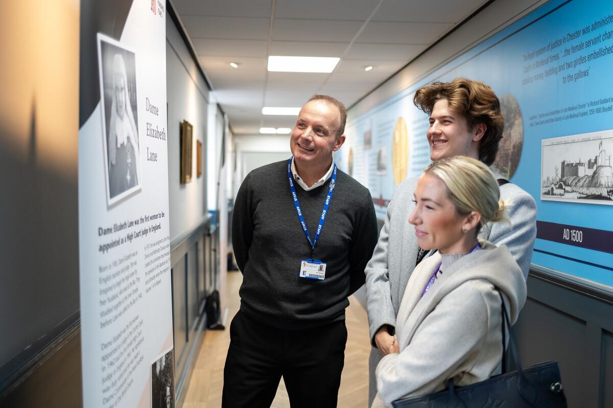 Law students and academic staff examining a legal history exhibition, supporting advanced study of international business law, commercial law, legal research and global legal practice on the LLM International Business and Commercial Law programme.