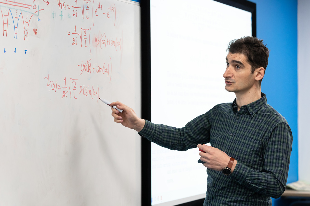 lecturer pointing at whiteboard