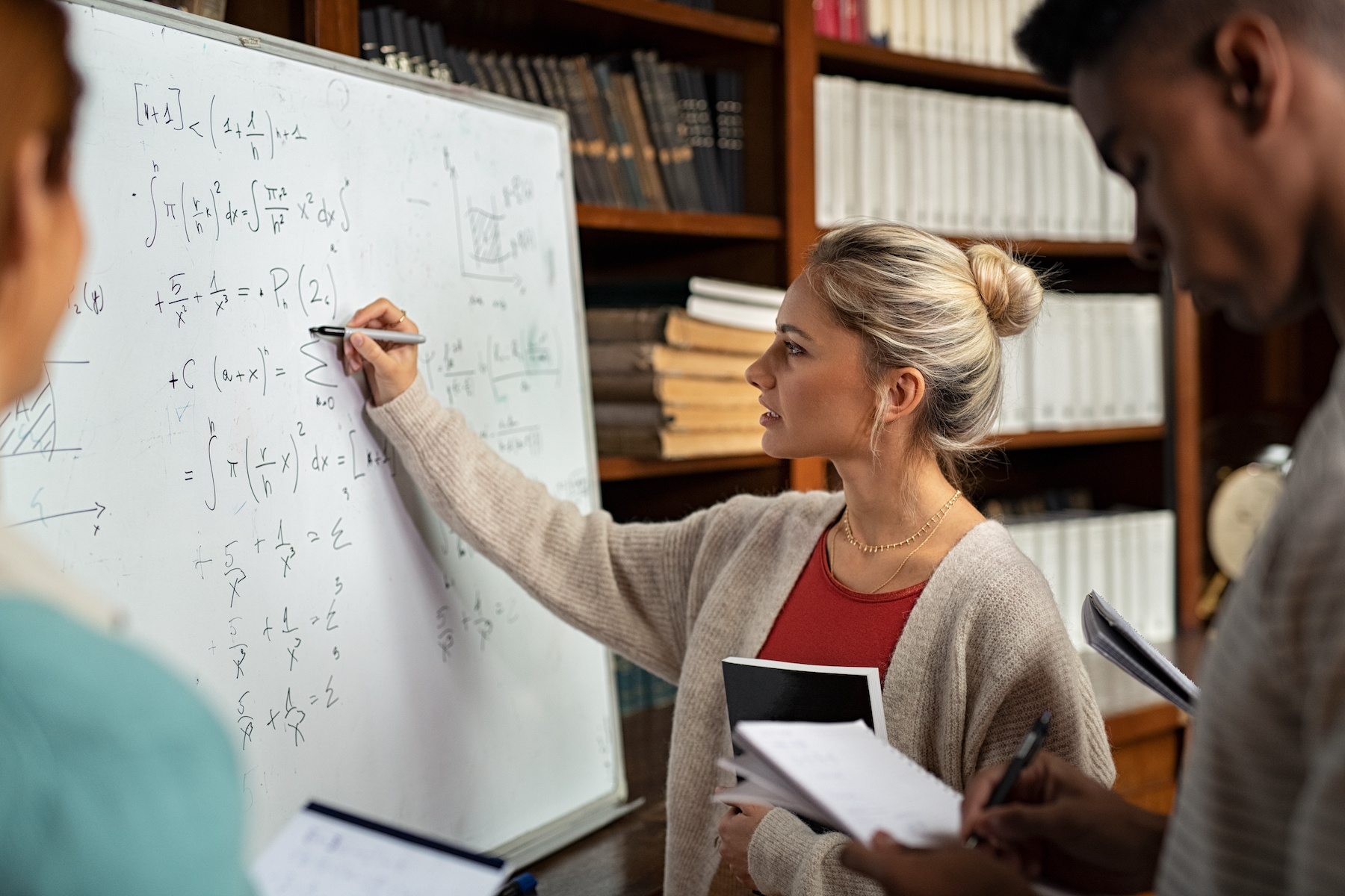 A female student solving math on whiteboard