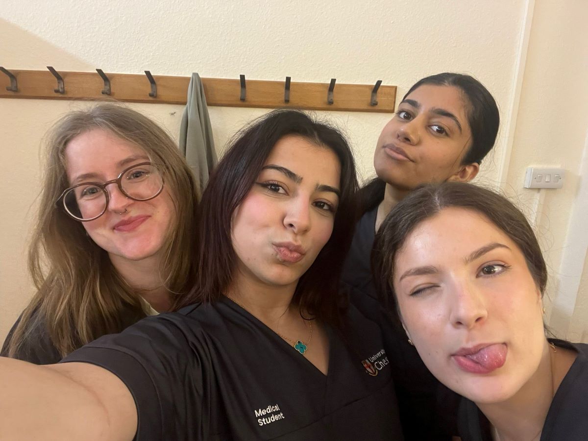 Mia in a group selfie with three friends wearing their medical scrubs