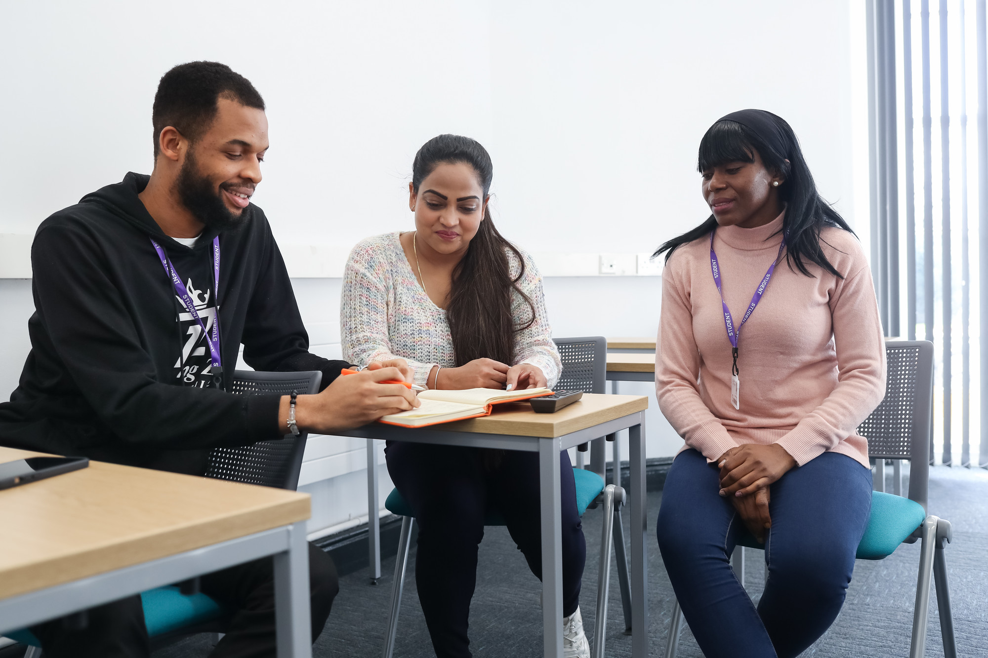 Three students having a discussion in the classroom