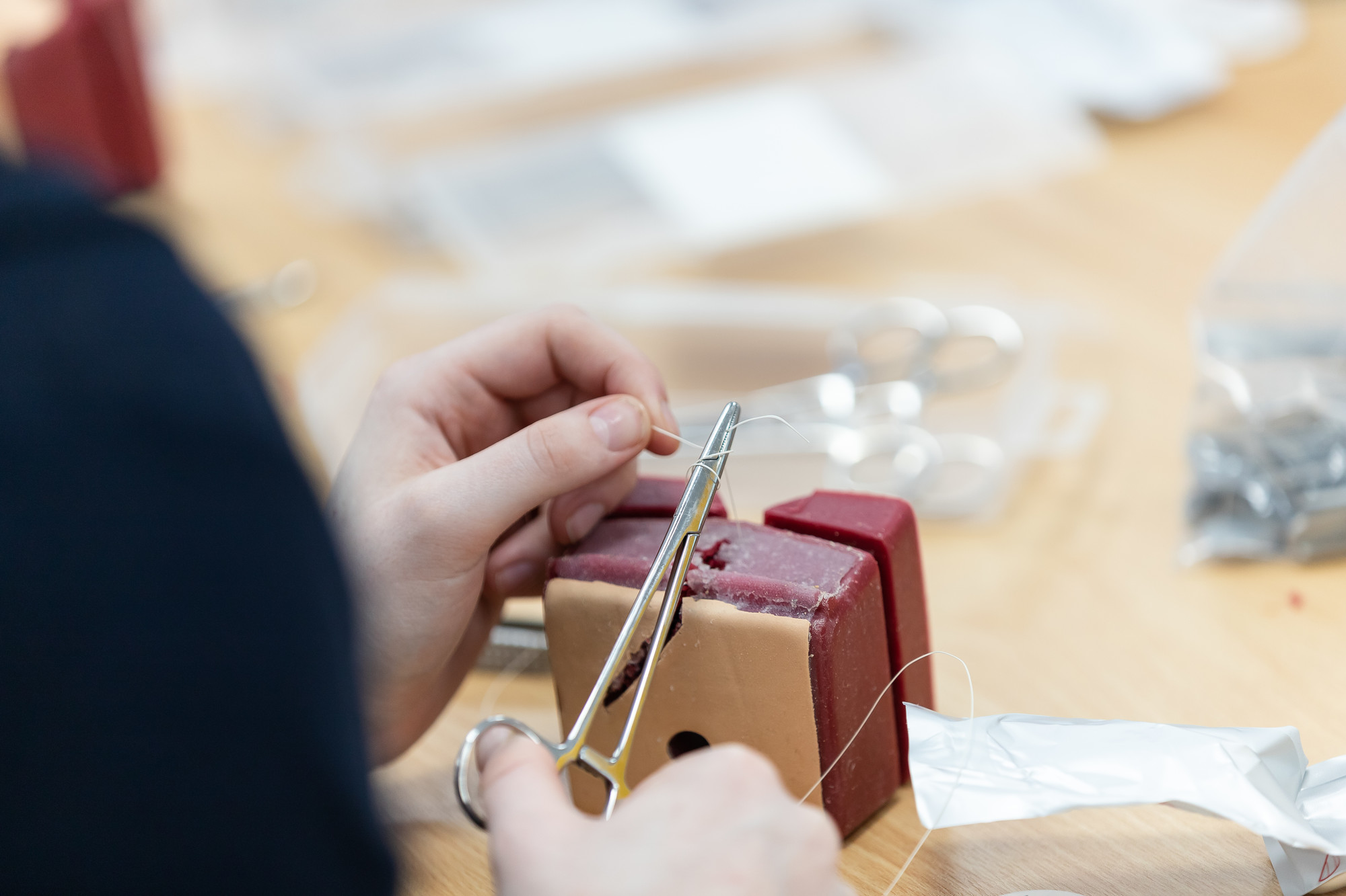 Midwifery student holding scissors during suture practice