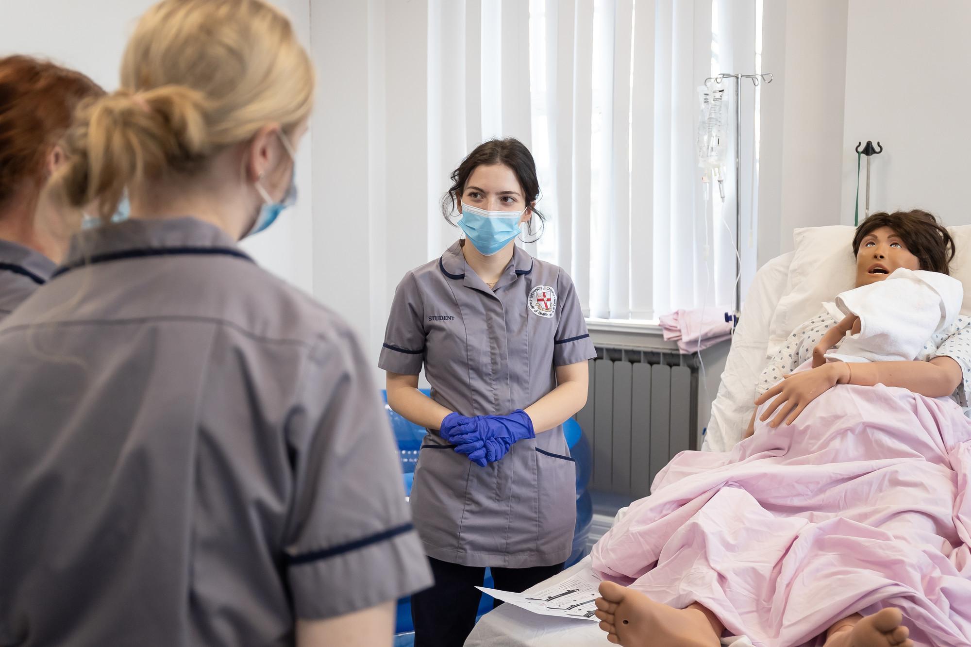 Nursing apprentices take part in clinical simulation training using a patient mannequin in a healthcare skills lab, developing practical patient care and professional skills for the Registered Nurse (Degree Apprenticeship) BN at the University of Chester.