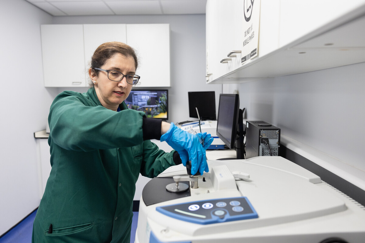In the Natural Science facilities at the University of Chester, a woman in a lab coat and gloves works on a machine.