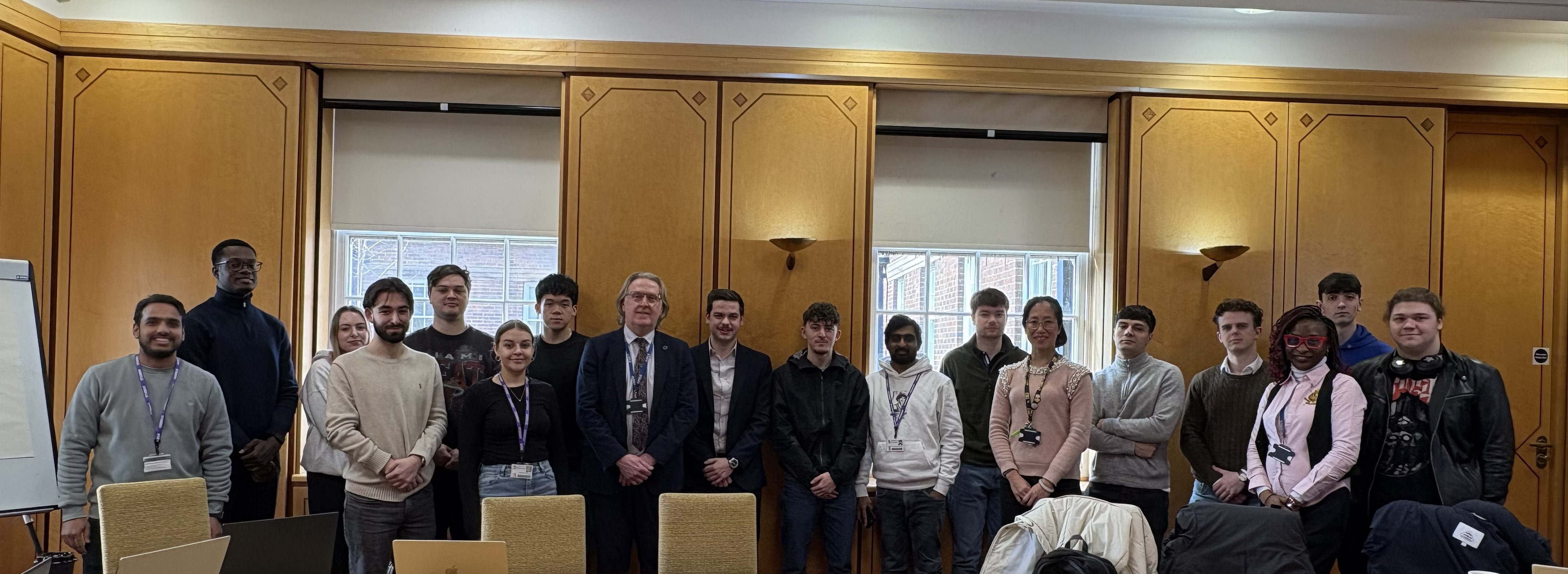 A row of students and staff in a line, all looking at the camera.