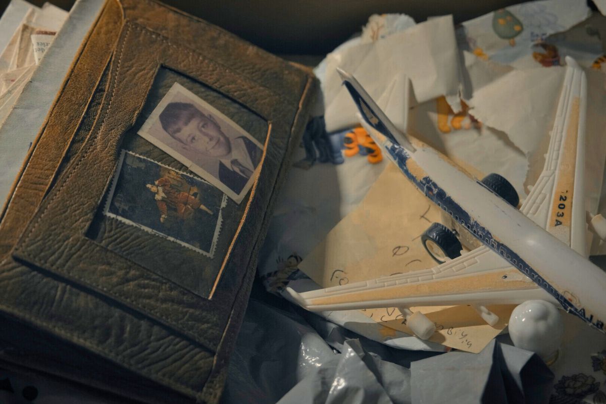 Screengrab from a film. The picture includes a wallet containing two photos of young children. Wrapping paper and a note with child