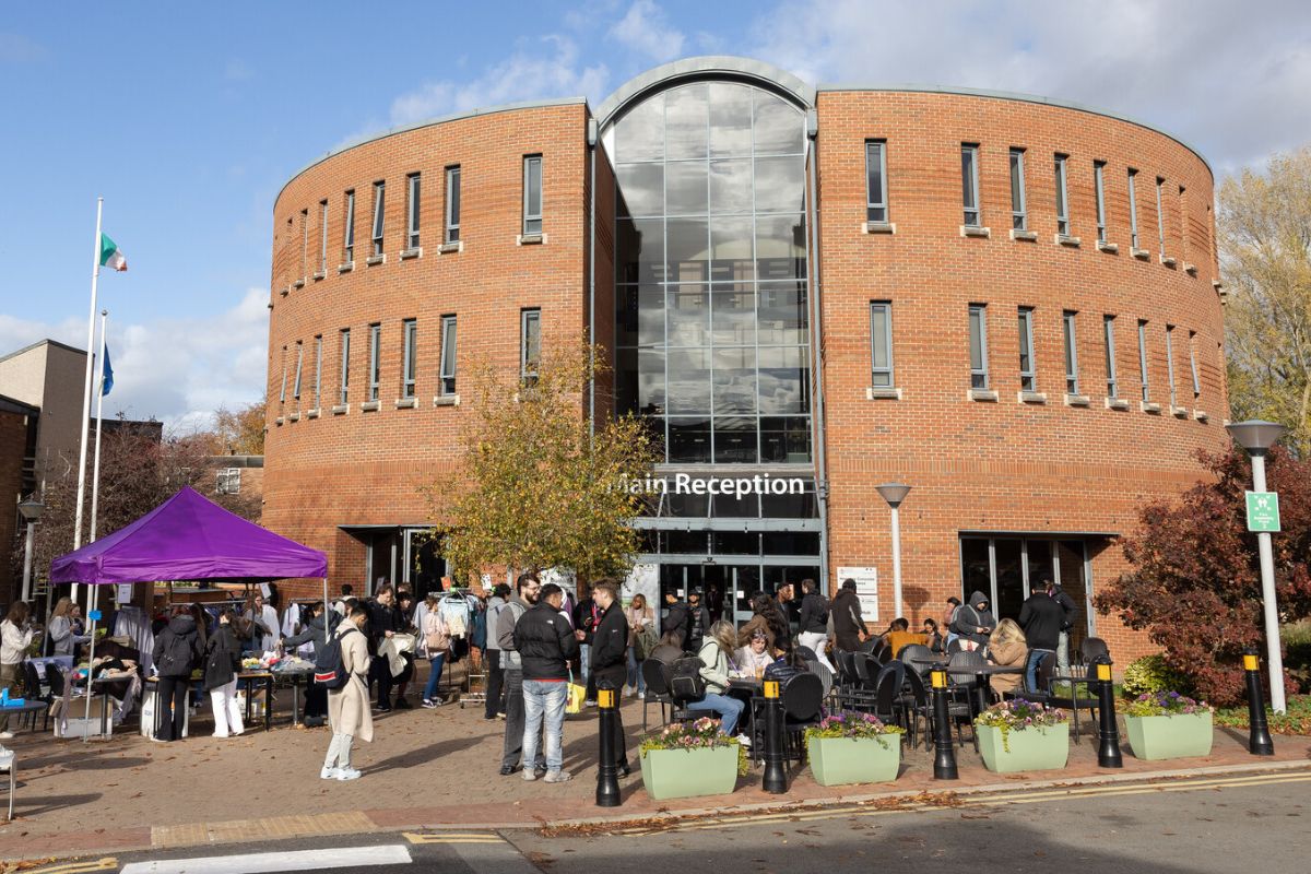 A scene shot of the Binks building in the background, with a number of people walking around near the entrance.