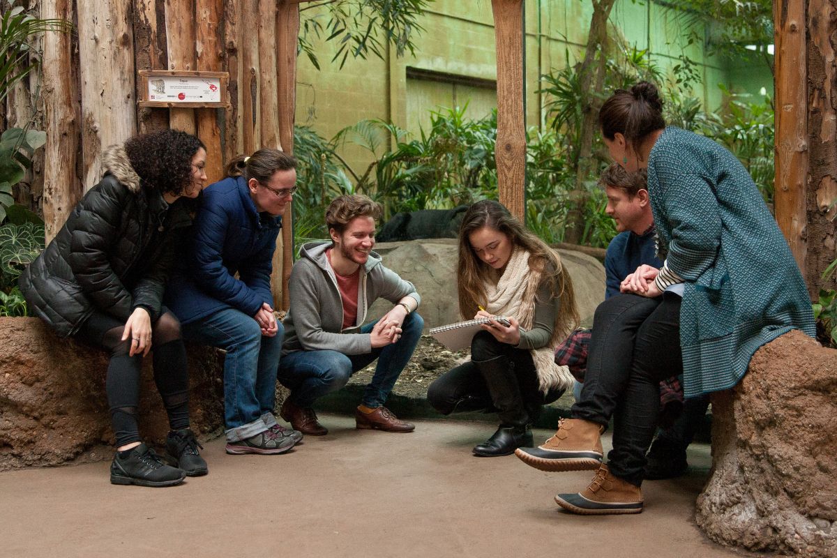 A group of people sat in a circle at Chester Zoo.