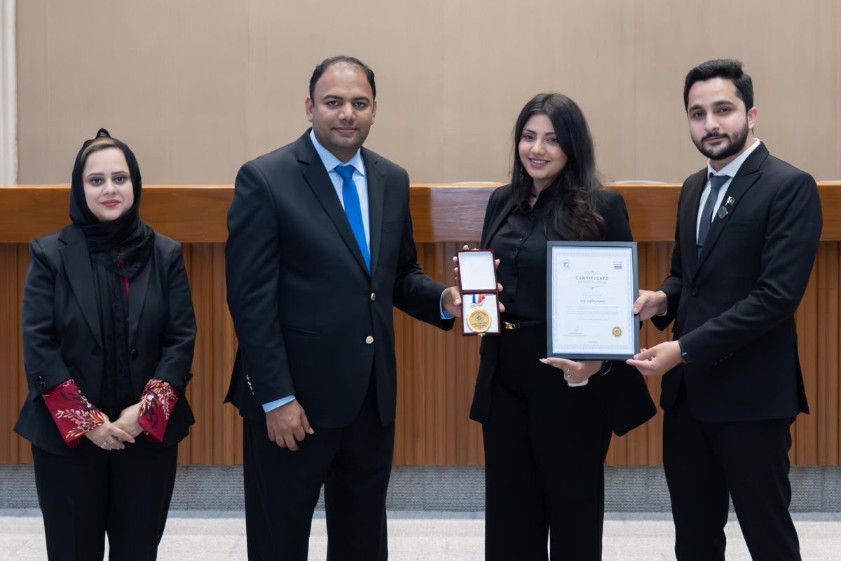 Four people looking at the camera as a presentation is made