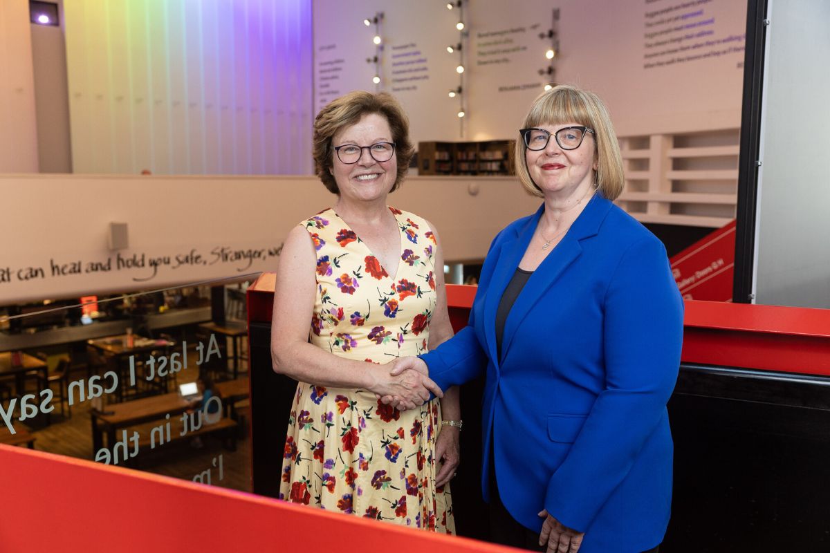 The Vice-Chancellor and the Chief Executive of Storyhouse looking at the camera, smiling, while shaking hands.