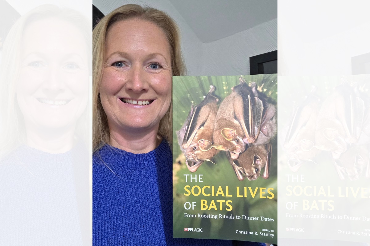 Professor Christina Stanley, smiling at the camera, holding a copy of her new book, with the cover shown to the camera. It reads 