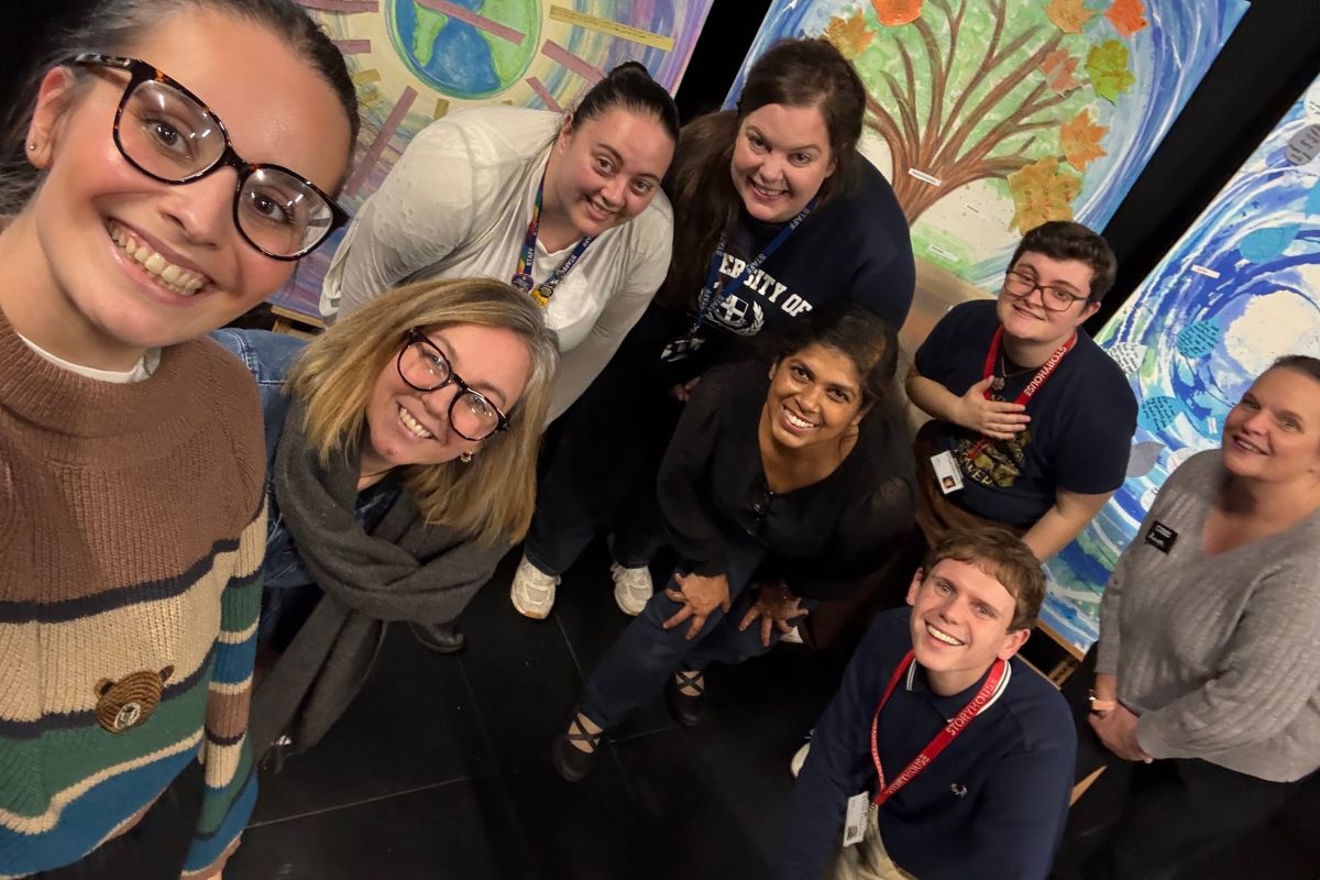 An angled photo of a group of people smiling at the camera