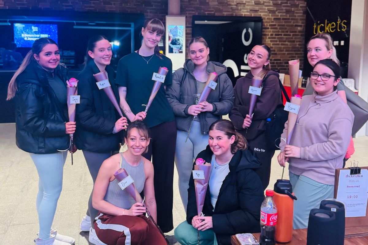 A group of people standing and kneeling, smiling at the camera.