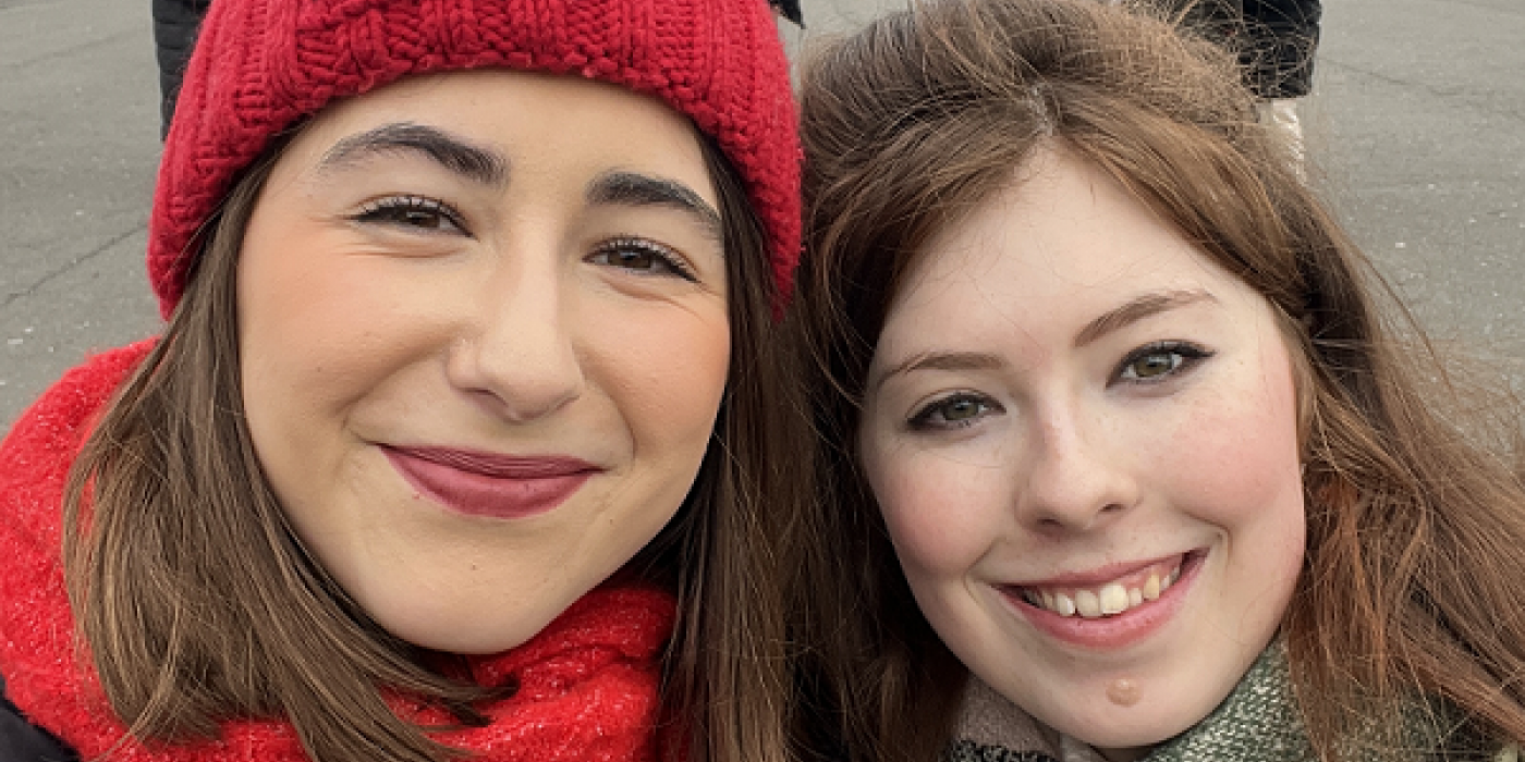 Two students smile into the camera