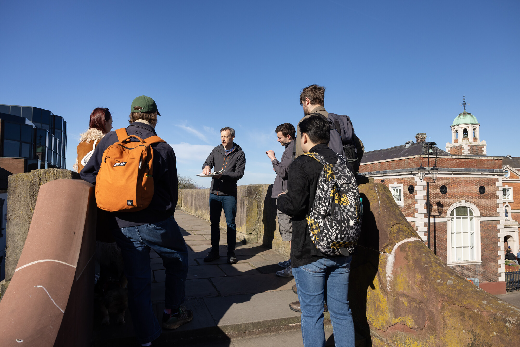 A group of people on Chester's City Walls listening to a talk.