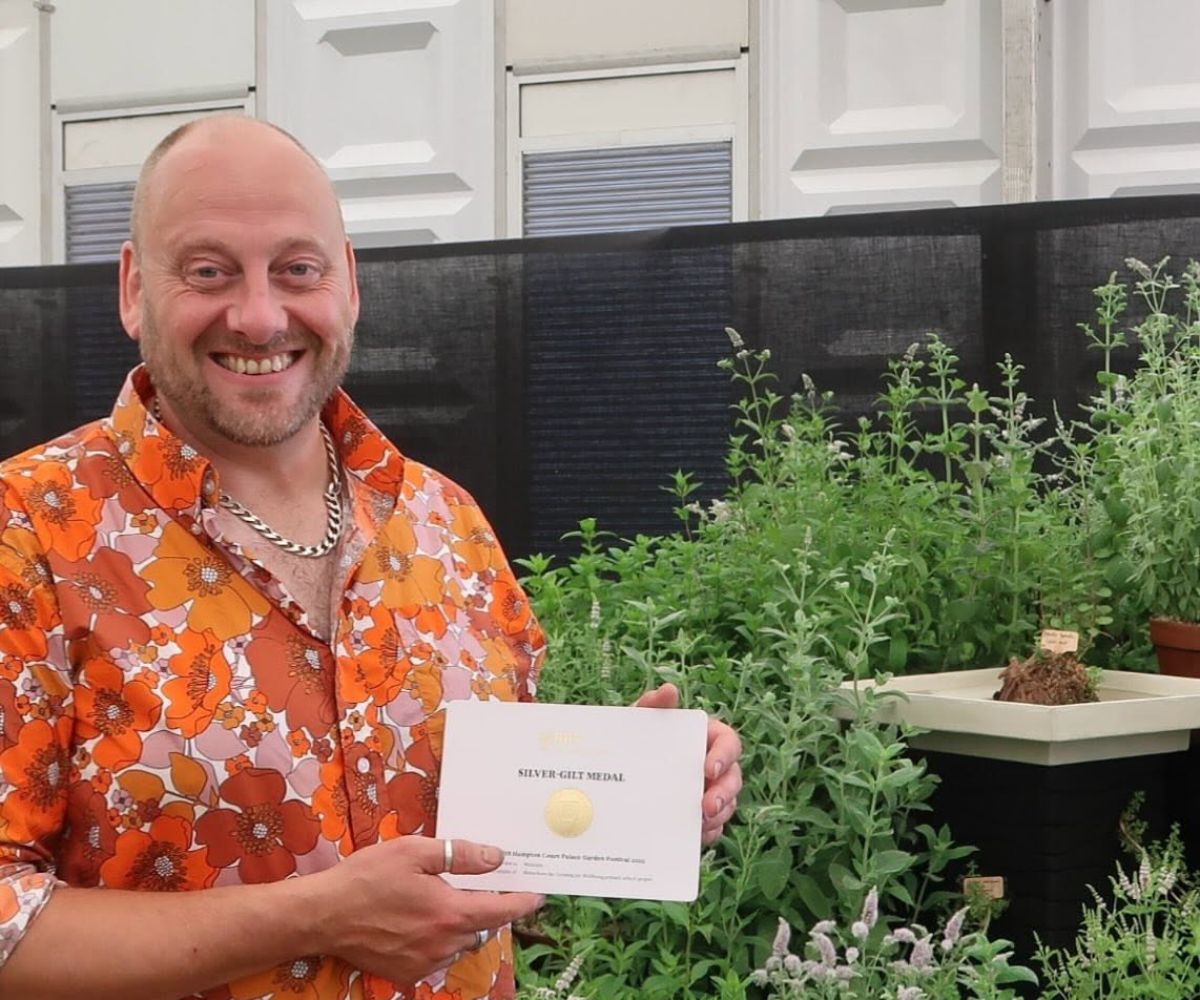 Dr Si Poole, Associate Professor of Cultural Education, with a Royal Horticultural Society Silver-Gilt award. Credit - Plant Heritage.